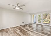 Thumbnail 5 of 24 - A room with a ceiling fan and wood flooring.