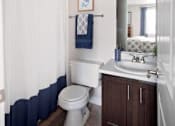 Thumbnail 8 of 23 - A white toilet sits in a bathroom next to a sink.
