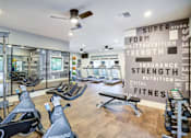 Thumbnail 3 of 23 - A gym with a row of stationary bikes and a wall of motivational words.