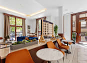 Thumbnail 15 of 32 - A modern living room with a long table and chairs.