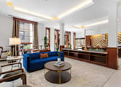 Thumbnail 16 of 32 - A living room with a blue sofa and a coffee table.