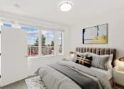 Thumbnail 8 of 32 - A bedroom with a large bed and a window overlooking a residential area.