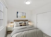 Thumbnail 9 of 32 - A bedroom with a large bed and a painting on the wall.