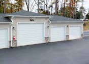 Thumbnail 30 of 31 - A three-car garage with a fire extinguisher on the left side.