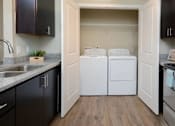 Thumbnail 5 of 31 - A kitchen with black cabinets and white appliances.