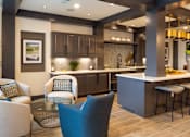Thumbnail 1 of 16 - A modern kitchen with a bar area and seating.
