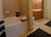 Thumbnail 16 of 16 - A bathroom with a tub, sink, and toilet.