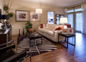 Thumbnail 9 of 16 - A living room with a white couch, a coffee table, and a ceiling fan.