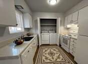 Thumbnail 6 of 21 - A kitchen with white appliances and cabinets.