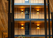 Thumbnail 6 of 40 - A modern building with wooden balconies and black railings at Brookland Apartments, Portland
