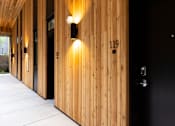 Thumbnail 31 of 40 - the lobby of the building has wooden walls and black doors at Brookland Apartments, Portland, OR 97202