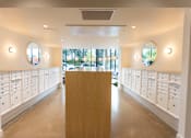 Thumbnail 14 of 40 - a dressing room with white lockers and a table in the middle at Brookland Apartments, Portland, Oregon