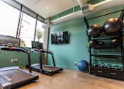 Thumbnail 8 of 40 - A gym with treadmills, a rowing machine, and a weight rack at Brookland Apartments, Portland