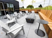 Thumbnail 35 of 40 - a patio with chairs and tables and a fire pit at Brookland Apartments, Portland