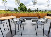 Thumbnail 29 of 40 - a patio with tables and chairs and a pool at Brookland Apartments, Oregon