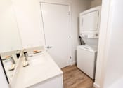 Thumbnail 34 of 40 - a small bathroom with a sink and a washer and dryer in a room at Brookland Apartments, Portland, Oregon