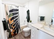 Thumbnail 30 of 40 - a bathroom with a shower and a sink and a toilet at Brookland Apartments, Oregon 97202