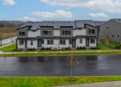 Thumbnail 23 of 46 - Exterior view of building with bushes and a sidewalk at Thrive at Green Mountain, Camas, WA