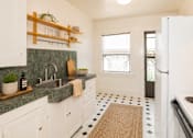 Thumbnail 4 of 13 - A kitchen with white cabinets and a green counter top.