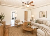 Thumbnail 2 of 13 - A living room with a white couch, a wooden coffee table, and a ceiling fan.