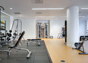 Thumbnail 12 of 78 - A gym with a variety of equipment including weights and cardio machines.