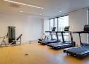 Thumbnail 11 of 78 - A gym with treadmills, a stationary bike, and a rowing machine.