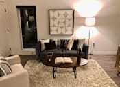 Thumbnail 4 of 24 - A living room with a grey couch and a coffee table.