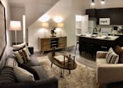 Thumbnail 3 of 24 - A modern living room with a kitchen area in the background.