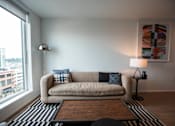 Thumbnail 2 of 19 - a living room with a couch and a large window at Analog Tacoma, Tacoma, WA, 98402