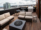 Thumbnail 8 of 19 - a rooftop deck with couches and a table at Analog Tacoma, Washington 98402