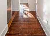 Thumbnail 12 of 28 - A long hallway with a wooden floor and white walls at Midtown  Apartments, Portland, OR