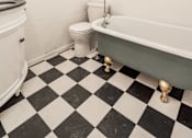 Thumbnail 9 of 28 - A white bathroom with black and white checkered floor at Midtown Apartments, Oregon