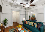 Thumbnail 21 of 28 - A living room with a green couch and a ceiling fan at Midtown  Apartments, Portland, OR