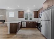 Thumbnail 35 of 46 - Modern kitchen with a stainless steel refrigerator and wooden cabinets at Thrive at Green Mountain, Camas, WA, Washington