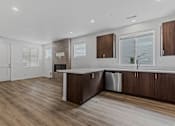 Thumbnail 43 of 46 - Modern kitchen with wooden floors and cabinets at Thrive at Green Mountain, Washington  , 98607