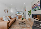 Thumbnail 2 of 46 - Living room with a fireplace and a television at Thrive at Green Mountain, Camas