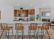 Thumbnail 4 of 46 - Kitchen with a white countertop and wooden chairs at Thrive at Green Mountain, Washington