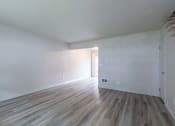 Thumbnail 16 of 18 - an empty room with white walls and a wooden floor
