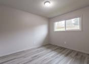 Thumbnail 10 of 18 - an empty room with a window and a wooden floor
