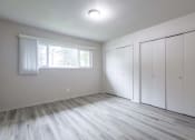 Thumbnail 12 of 18 - an empty bedroom with a large window and white closets