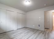 Thumbnail 7 of 18 - a bedroom with white walls and a wooden floor