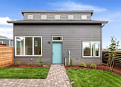 Thumbnail 20 of 24 - a gray house with a blue door