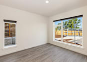 Thumbnail 23 of 24 - a bedroom with two large windows and a wooden fence