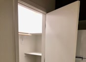 Thumbnail 14 of 24 - A white closet with a black handle and a shelf.