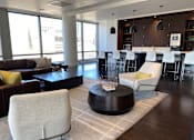 Thumbnail 15 of 78 - A modern living room with a brown sofa, white chairs, and a coffee table.