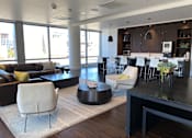 Thumbnail 16 of 78 - A modern living room with a black coffee table and white chairs.