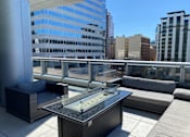 Thumbnail 21 of 78 - A table with a glass top is in the foreground of an outdoor patio area.