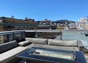 Thumbnail 18 of 78 - A rooftop patio with a hot tub and couches.