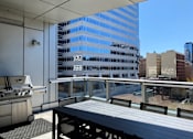 Thumbnail 22 of 78 - A barbecue grill is on a patio overlooking a cityscape.