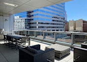 Thumbnail 20 of 78 - A patio with a table and chairs overlooking a cityscape.